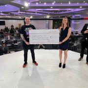 Jess and James Whiston holding the cheque at Fight Night