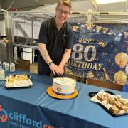 Managing director John Clifford cuts 80th birthday cake